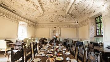 Ein formeller Speisesaal mit aufwendiger Decke und klassischer Möbel.