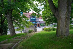 Un sendero que lleva a un edificio con techo rojo, rodeado de árboles y vegetación.