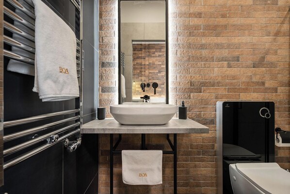 A modern bathroom with a large sink, a mirror, and a towel rack. - Vaci Boutique Loft Suites By Bqa (Budapest)