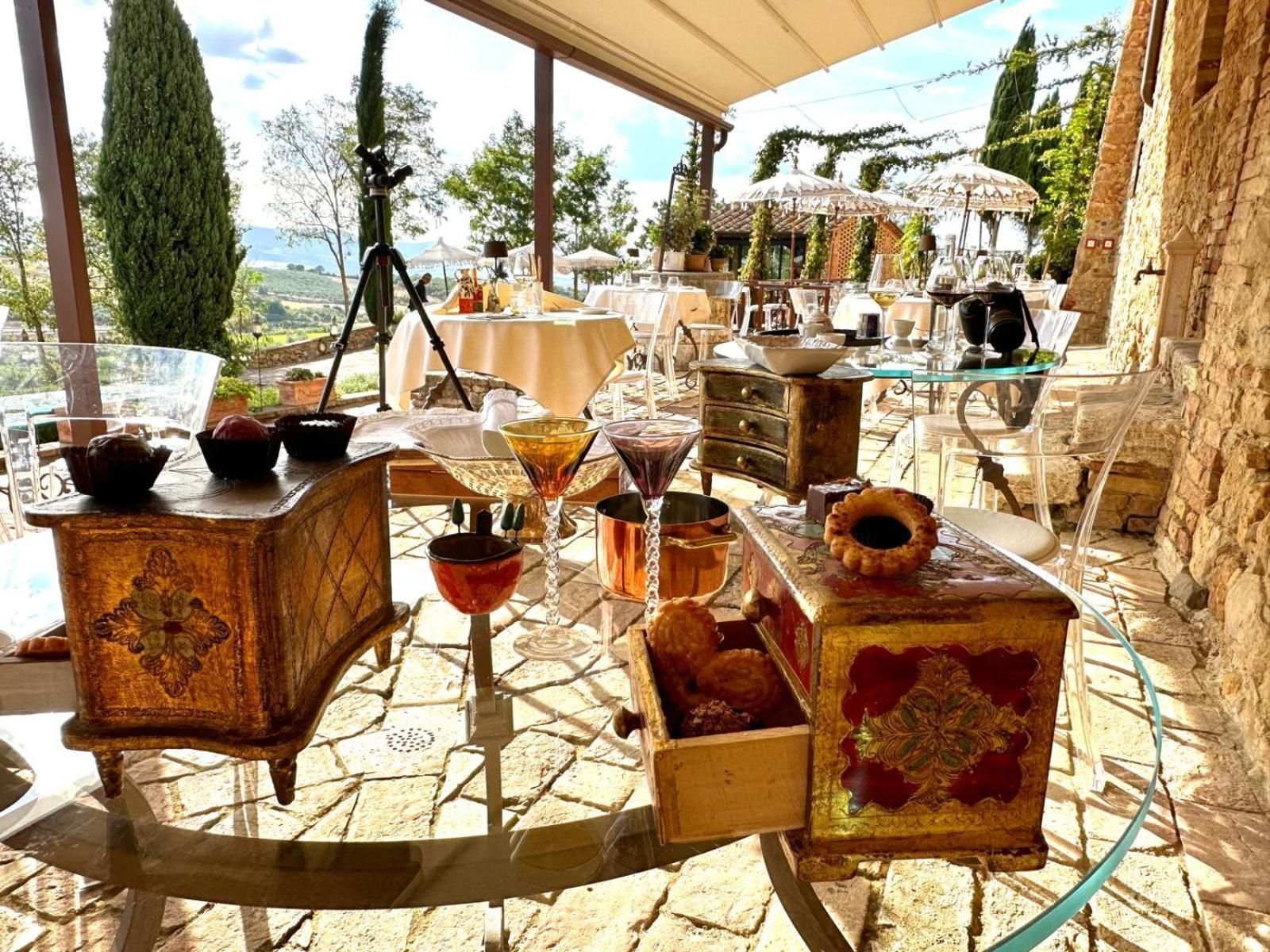 An outdoor dining area with stone flooring, tables, and chairs.