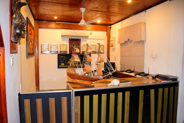 A room with a wooden ceiling, a ship model, clocks, and a desk with a telephone. - The Kings Island Resort (Negombo)