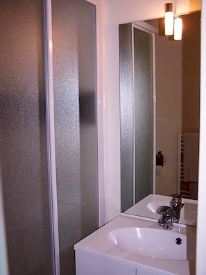 A bathroom with a white sink, a mirror, and frosted glass doors. - Le Lichou (Vallon-en-Sully)