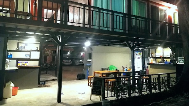 A two-story building with a balcony, a table with chairs, and a refrigerator. - Hat Yao Seaview Beach Room (Trang)
