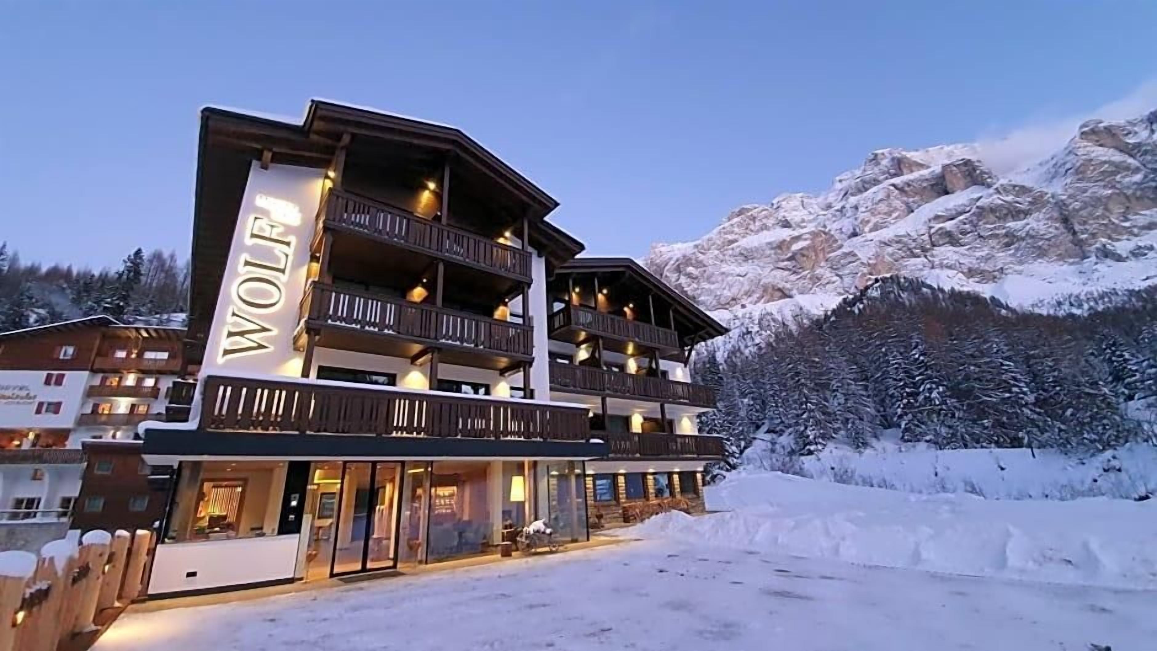 A multi-story building with balconies and a sign that reads 'WOLF'.