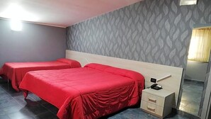 A hotel room with two beds, a bedside table with a phone, and a mirror. - Motel Kratos (Bisignano)