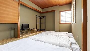 Una habitación con dos camas, televisión y ventana.