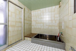 Ein kleines Badezimmer mit Fliesen, einer Dusche, einem Waschbecken und einer Toilette.