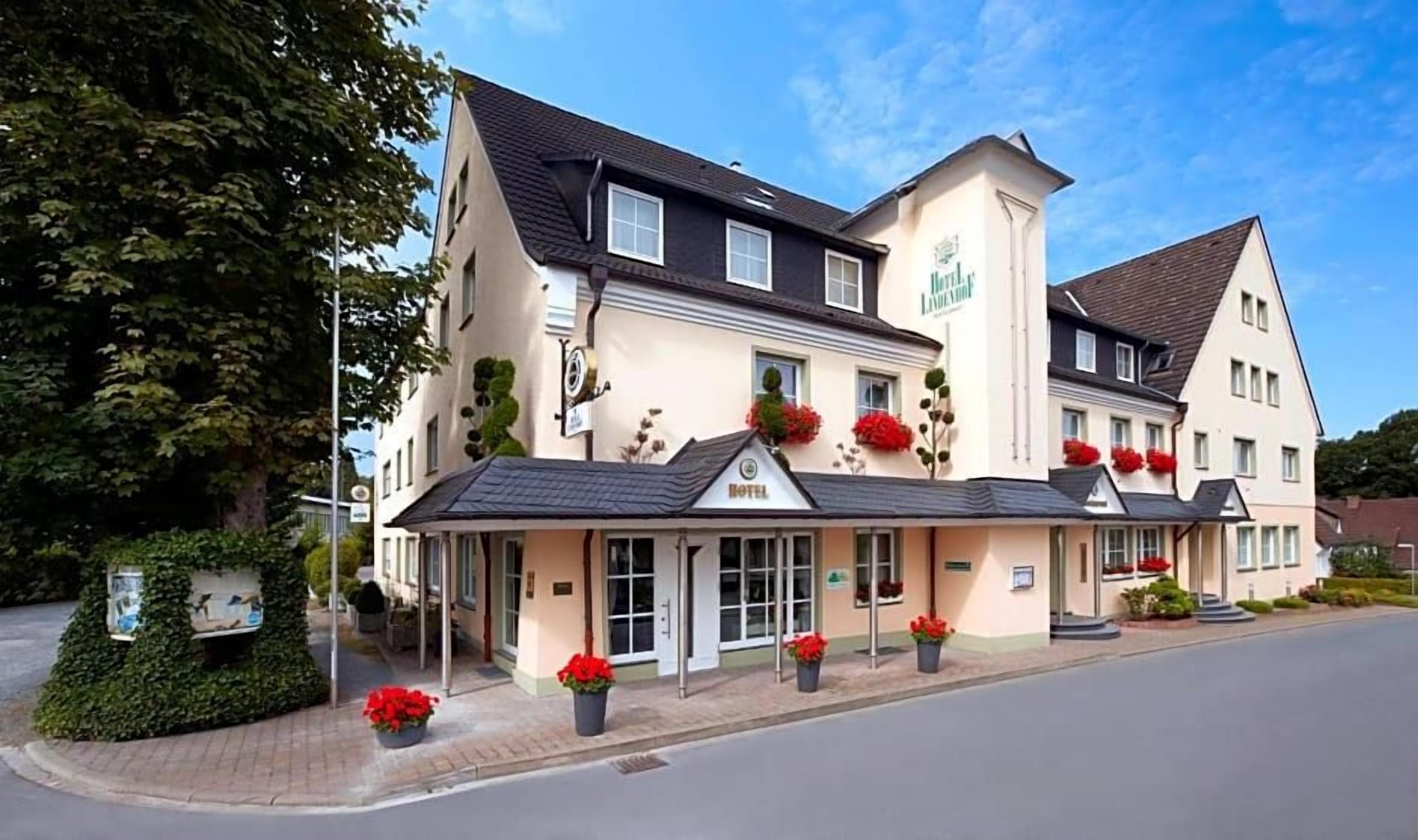 Ein Hotel mit einer zweistöckigen Struktur, einem überdachten Eingang und einem Schild, das es als Hotel kennzeichnet.