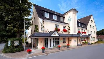 Ein Hotel mit einer zweistöckigen Struktur, einem überdachten Eingang und einem Schild, das es als Hotel kennzeichnet.
