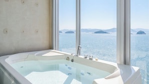 A large bathtub with a view of the sea and islands through a window. - ?? ???? ???? ?? (Yeosu)