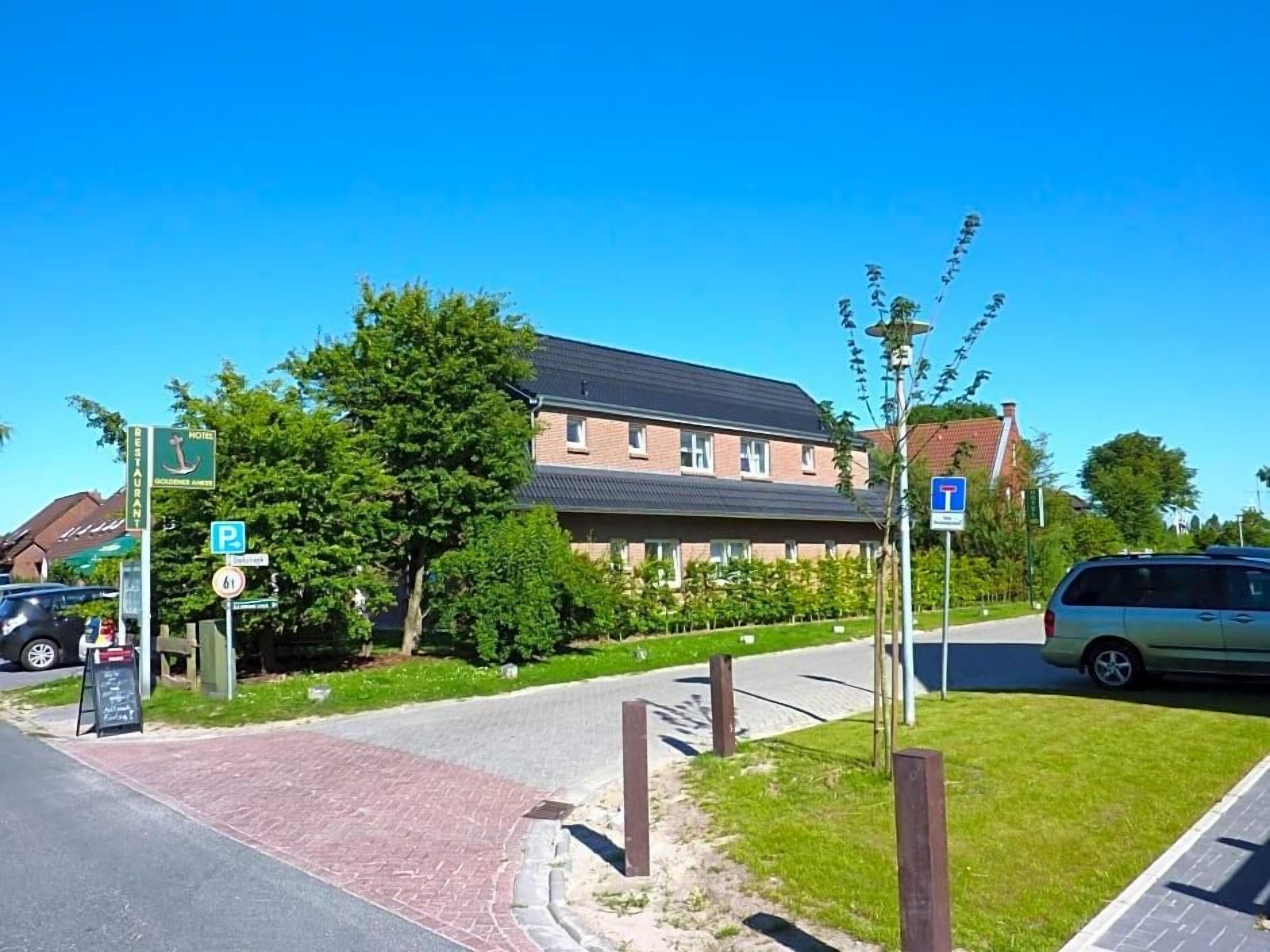 Een hotel met een parkeersbord, een restaurant en een gebouw met een schuin dak.