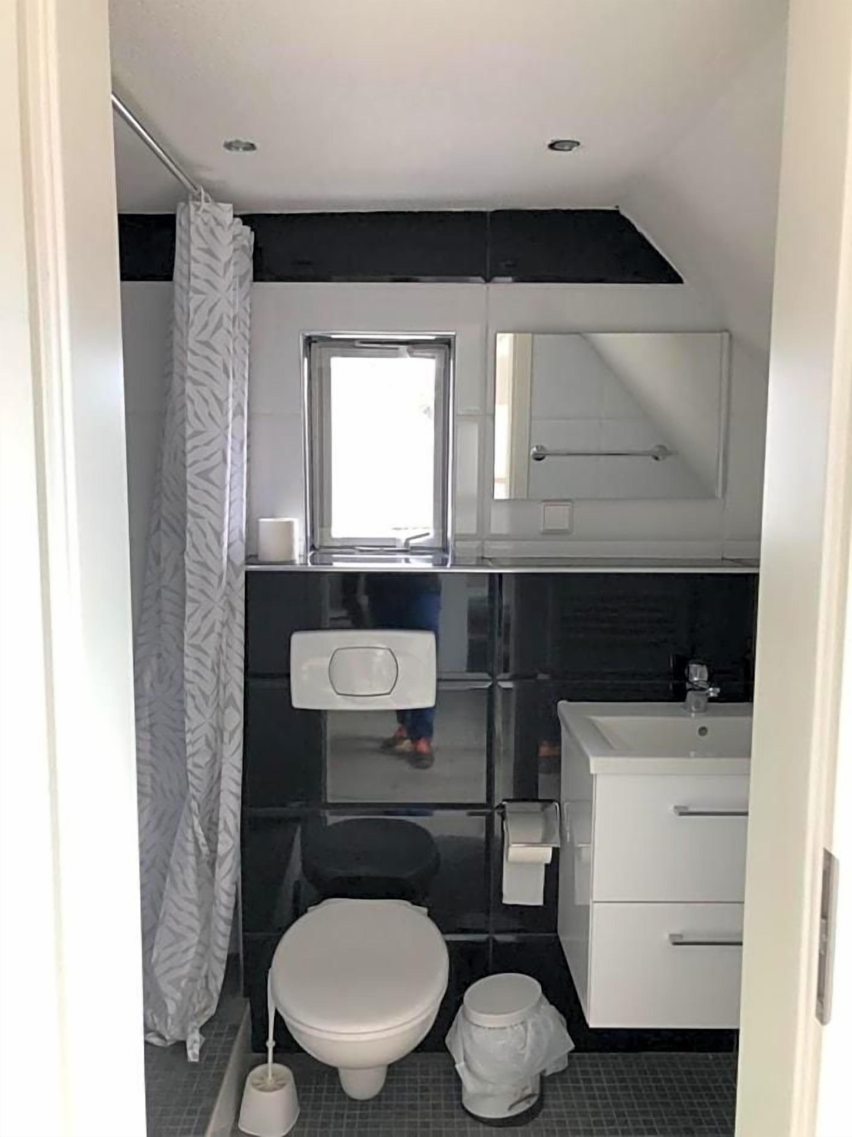 Ein kleines Badezimmer mit Toilette, Waschbecken und Duschbereich.