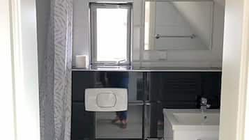 Ein kleines Badezimmer mit Toilette, Waschbecken und Duschbereich.