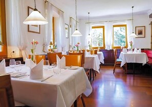 A dining area with multiple tables set for service, chairs, and hanging pendant lights. - Zv Fle Hotel Restaurant Spa (Sulz am Neckar)