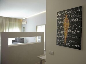 A modern interior with a wall-mounted artwork, a window with a view, and a neutral color palette. - Hotel Parco (Cervia)