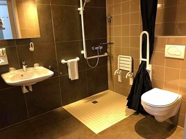 A modern bathroom with a sink, toilet, and shower.