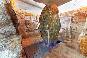 A stone interior with a metal railing and a blue-lit platform. - Landhotel Krone (Heitersheim)