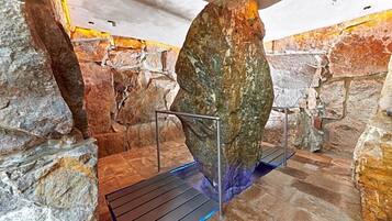 Ein Steingewölbe mit Metallgeländer und einer blau beleuchteten Plattform.