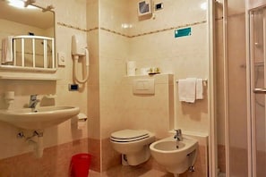Un bagno con lavandino, WC, bidet e doccia.