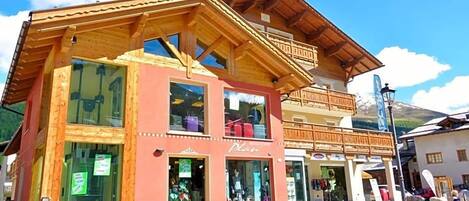A wooden building with multiple storefronts, including a visible sign that says 'Plan'.