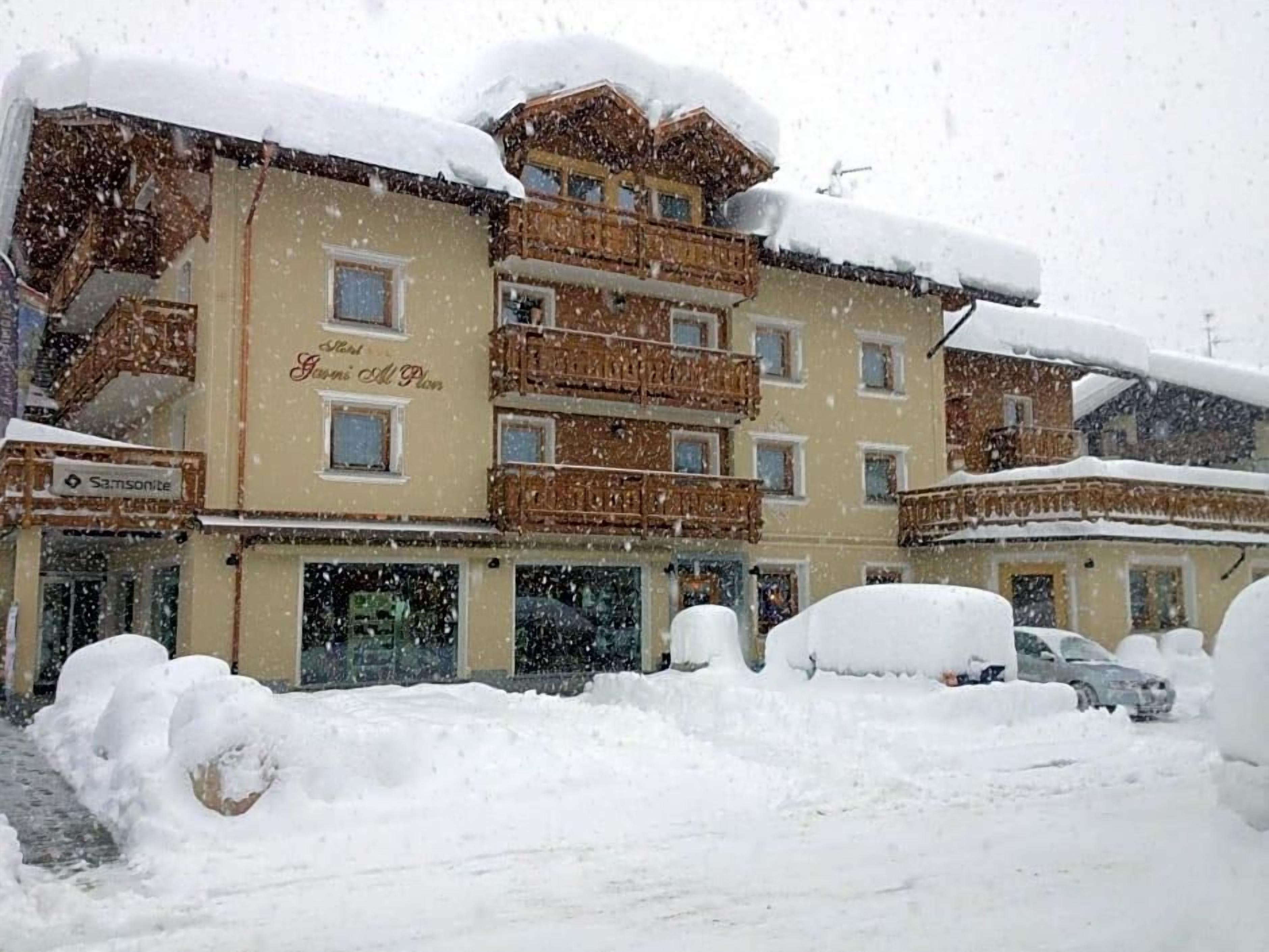 A hotel with multiple balconies and a sign that reads 'Hotel Gamsbich.'