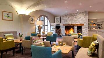A hotel lobby with seating areas, a fireplace, and artwork on the walls.