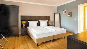 Ein Hotelzimmer mit Bett, Nachttischen, einem Schrank und einer Chandelier.