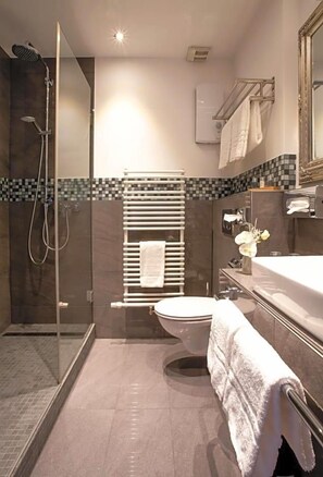 A modern bathroom with a glass-enclosed shower, a toilet, and a vanity with a mirror. - Hotel Royal Jvºlich (Jülich)