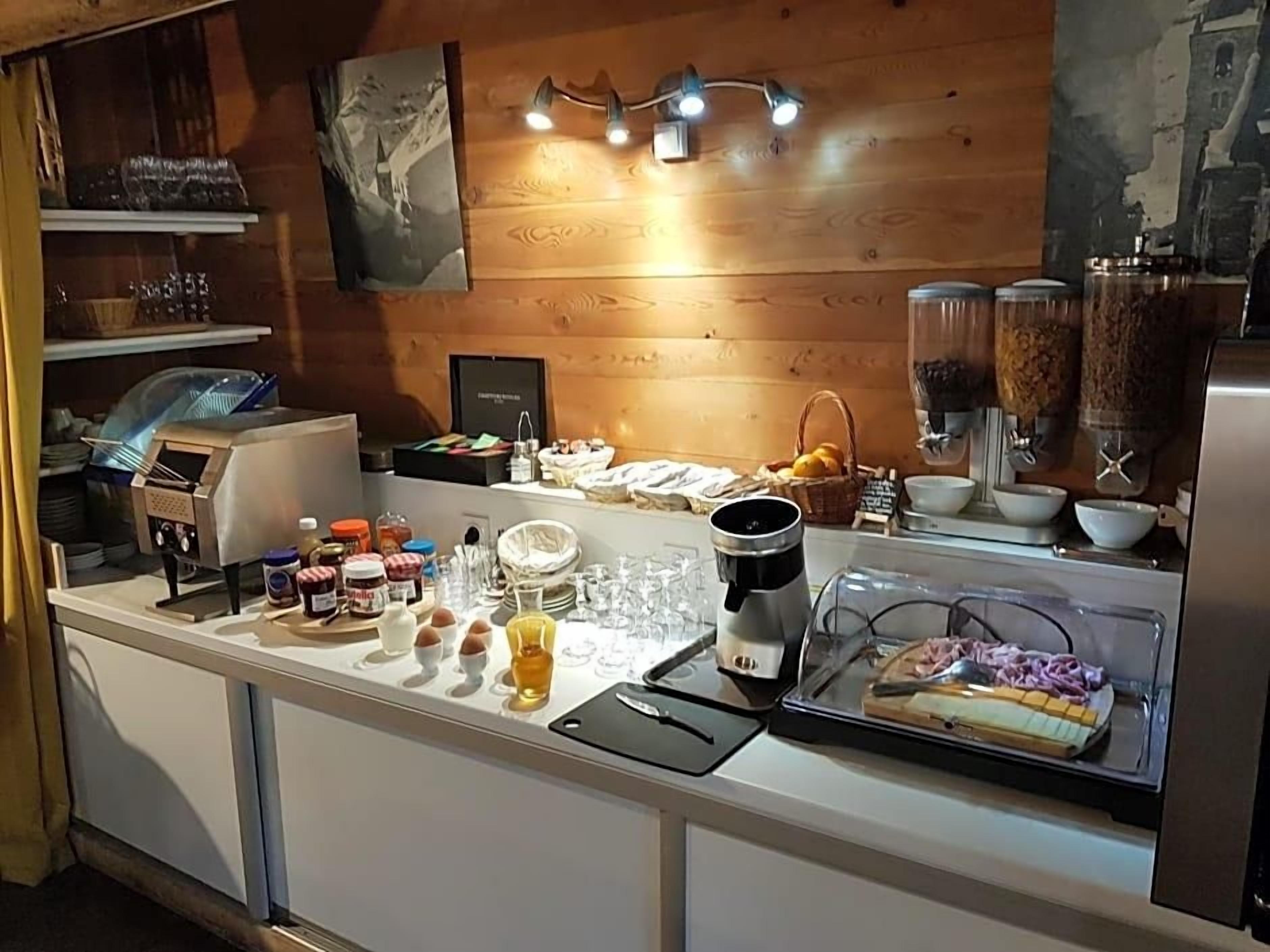 Un buffet proposant divers plats, une machine à café et un grand récipient pour servir du café.