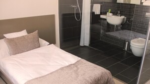 A hotel room with a bed, a shower, and a bathroom. - Hotel Lev (Levice)