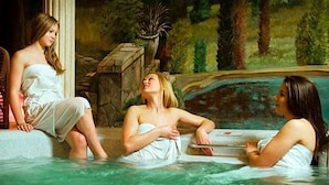 A spa setting with a hot tub and a stone wall.