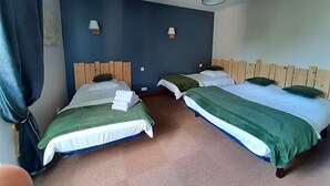 A hotel room with two beds, a ceiling fan, and wall-mounted lamps. - L Auberge Du Tire Bouchon (Couffé)