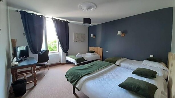 A hotel room with a bed, a desk with a computer, a chair, and a window with curtains. - L Auberge Du Tire Bouchon (Couffé)