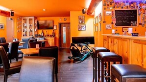 A restaurant interior with wooden furniture, a bar area, and a television mounted on the wall. - Land Gut Hotel Am Ring (Meuspath)