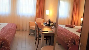 A hotel room with two beds, a desk, and a chair. - Land Gut Hotel Am Ring (Meuspath)