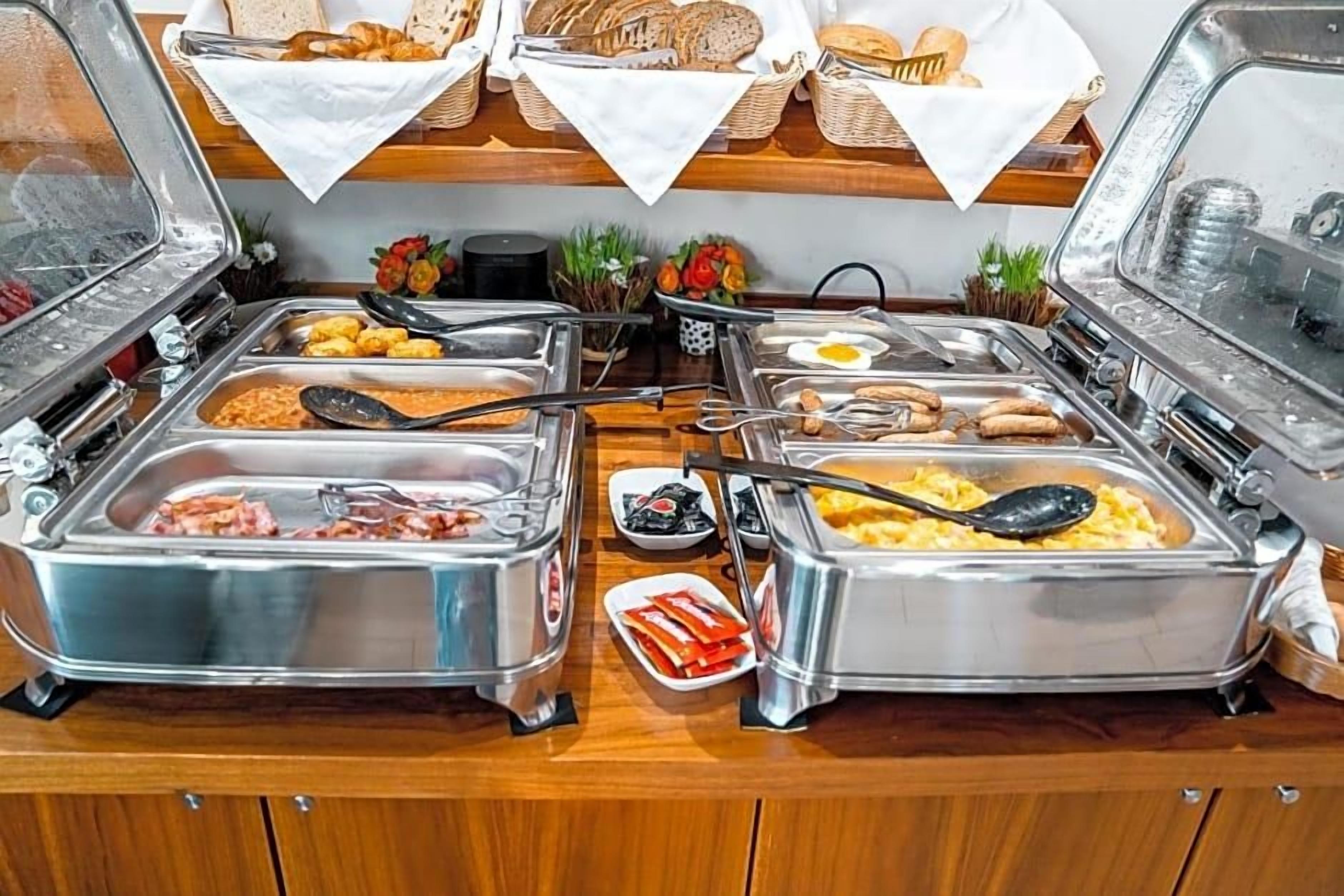 Een buffet met diverse gerechten, waaronder vleeswaren, eieren en brood.