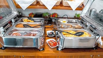 Ein Buffet mit verschiedenen Speisen, darunter Fleisch, Eier und Brot.