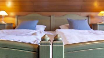 A double bed with a wooden headboard and two bedside lamps.