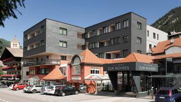 Ein Hotel mit moderner Fassade, mehreren Balkonen und einem Restaurant namens 'Zum Mohren' vor der Tür.