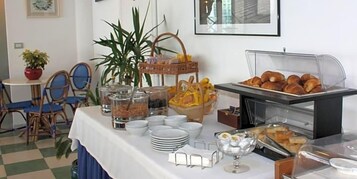 Un bufé de desayuno con diversas opciones de comida y utensilios.