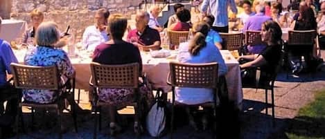 An outdoor dining area with stone buildings and a church steeple in the background.
