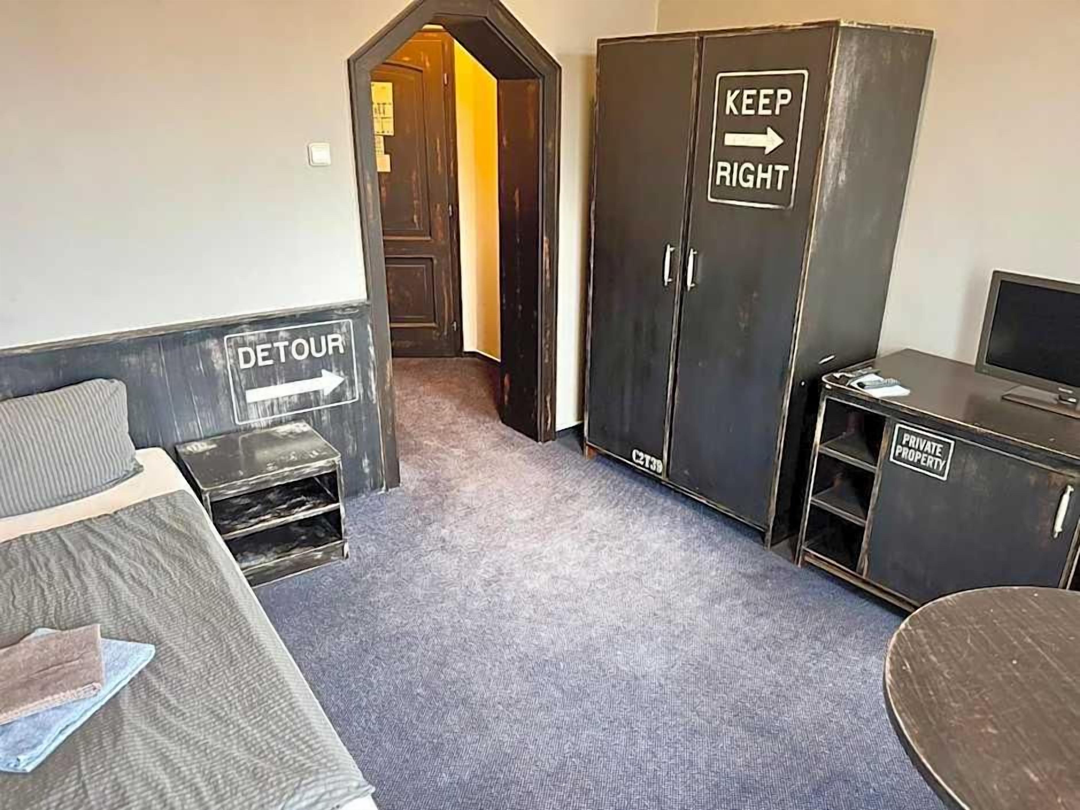Ein Zimmer mit einem Bett, einem Schreibtisch, einem Kleiderschrank und einem Schild, das privates Eigentum kennzeichnet.