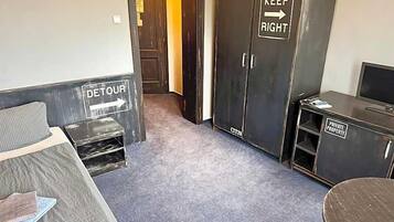 Ein Zimmer mit einem Bett, einem Schreibtisch, einem Kleiderschrank und einem Schild, das privates Eigentum kennzeichnet.