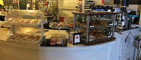 A bakery counter with various baked goods on display.