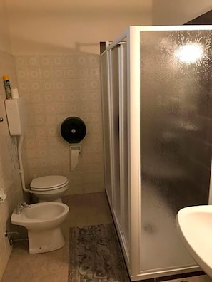 Kylpyhuone, jossa on wc, bidee ja suihkukaappi.