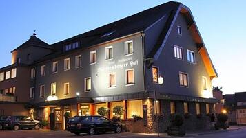 Ein Hotel mit Restaurant im Erdgeschoss, zahlreichen Fenstern und einer Steinfassade.