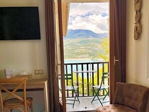 Une pièce avec un balcon, un canapé, une table et des chaises.