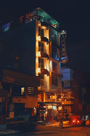 A multi-story hotel with a visible coffee shop on the ground floor, a balcony with outdoor seating, and a sign indicating the presence of a coffee shop. - Hotel Trugo (Armenia)