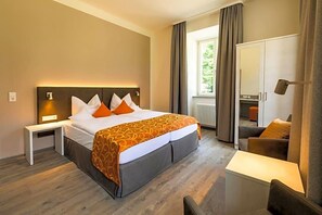 Une chambre d’hôtel avec un lit, une table de chevet, une chaise et une vue sur l’extérieur.