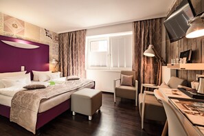 Una habitación de hotel moderna con una cama, un escritorio, una silla y un televisor.